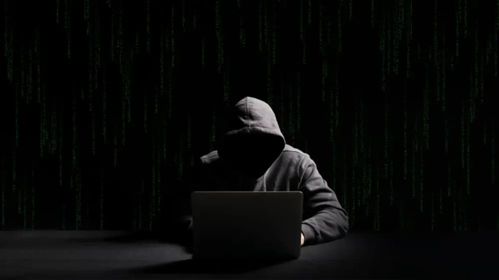Spear phishing concept with hacker silhouette over binary code